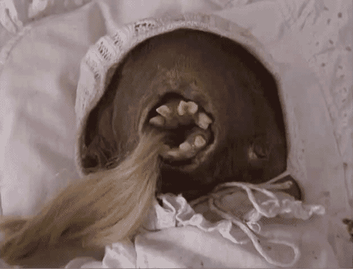 Mały Otik w kołysce pożera długie blond włosy.